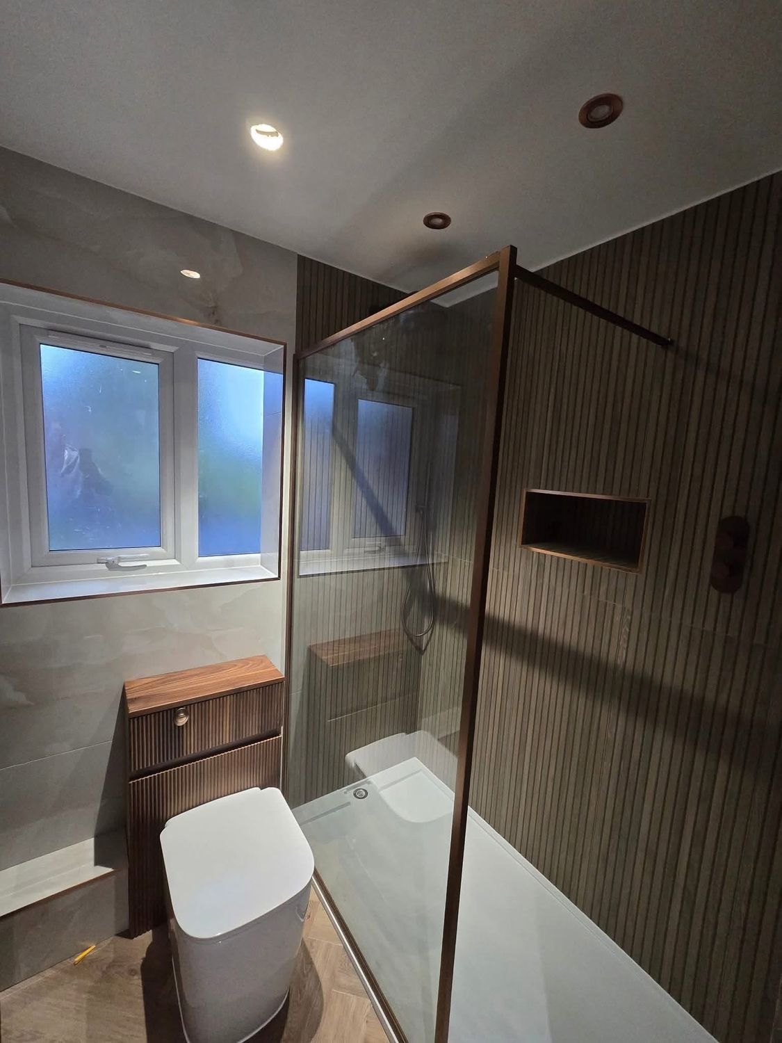 Bathroom renovation with walk-in shower and wood-effect tiles